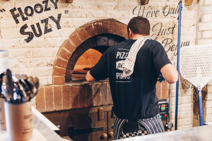 Chef putting Pizza in a Stone Pizza oven at The Carpenters Arms